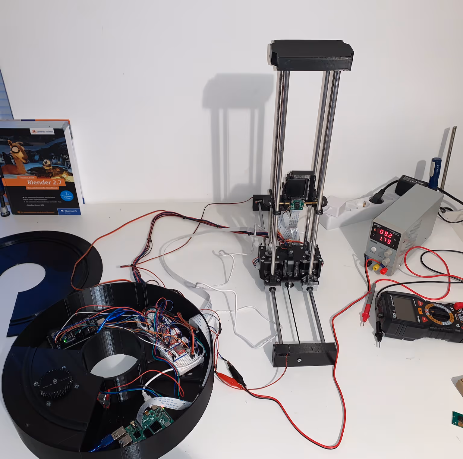 Complete test setup: turntable base with integrated Raspberry Pi and wiring, camera tower, lab power supply and multimeter
